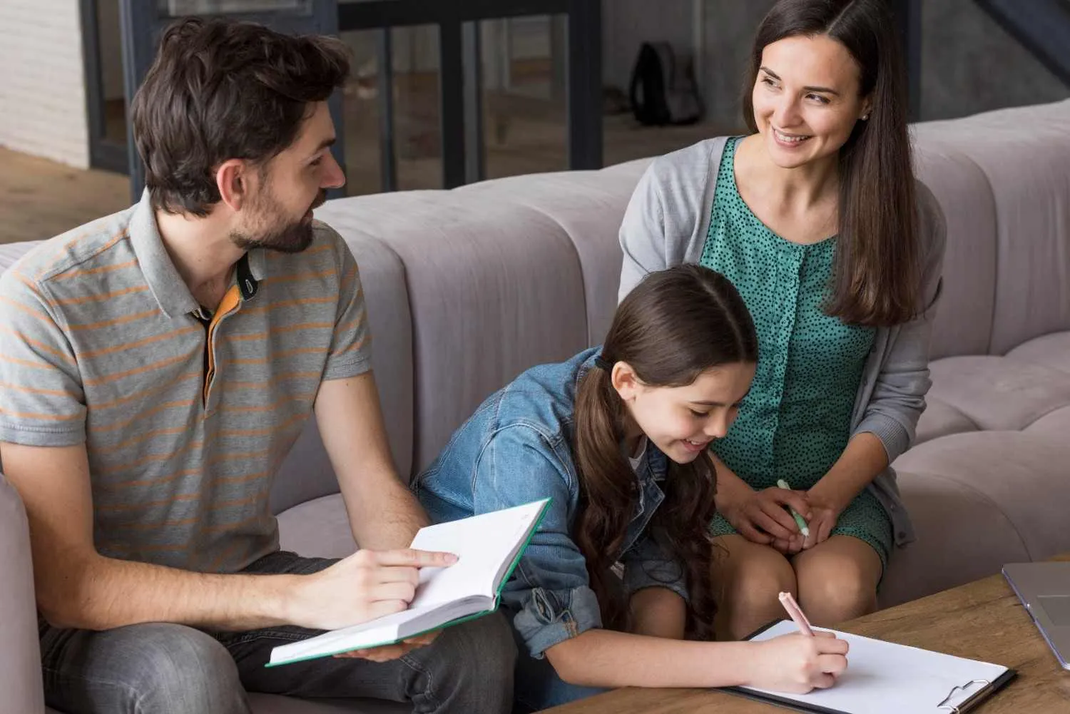 Parents and their daughter going over health plan notes together on the sofa